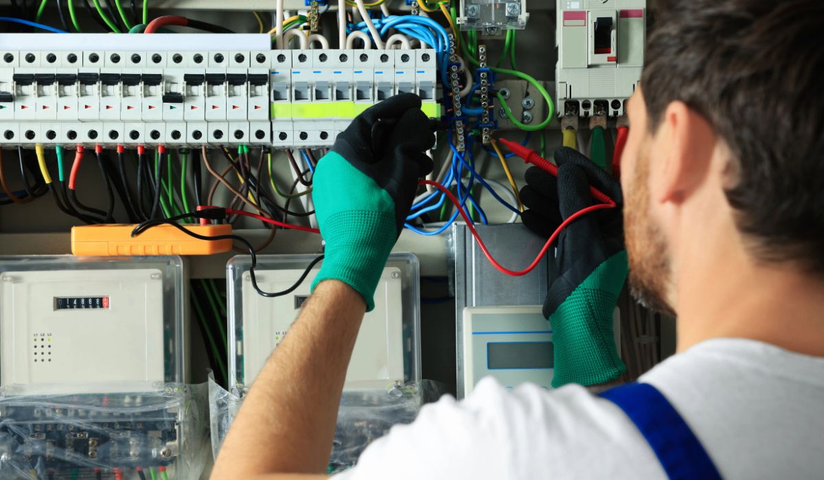 Elektriker prüft Sicherungskasten mit Messgerät